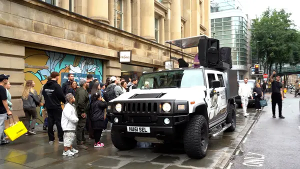 Crowd gathered around a DJ truck on a rainy street