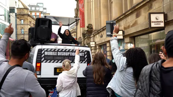 Crowd dancing around a DJ truck in a city centre