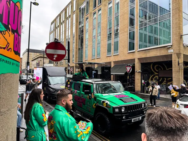 Dancers in costume next to the DJ truck on a city street