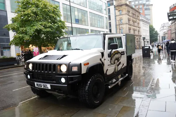 White DJ truck driving through a wet city street