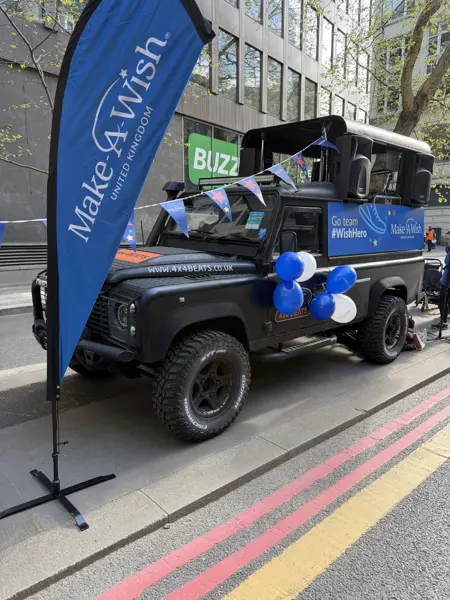 DJ truck with charity flags set up beside a race route