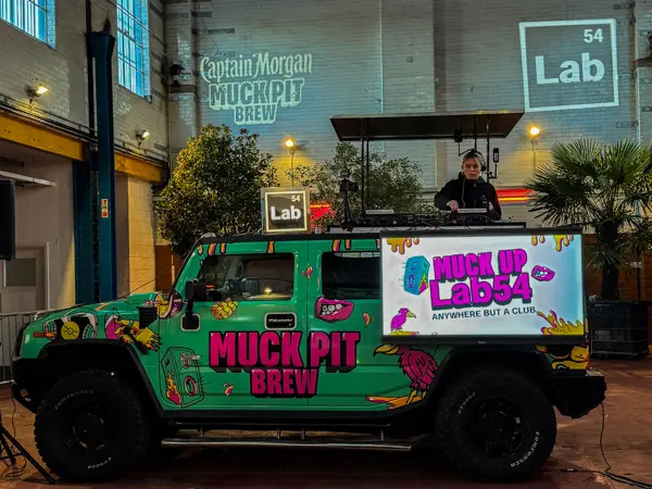Wrapped DJ truck with a DJ playing outside a city bar