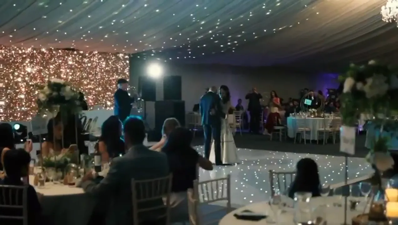 Saxophonist playing live for a couple's first dance in a marquee
