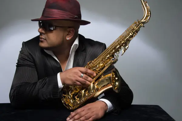 Saxophonist in a hat and sunglasses with a gold saxophone