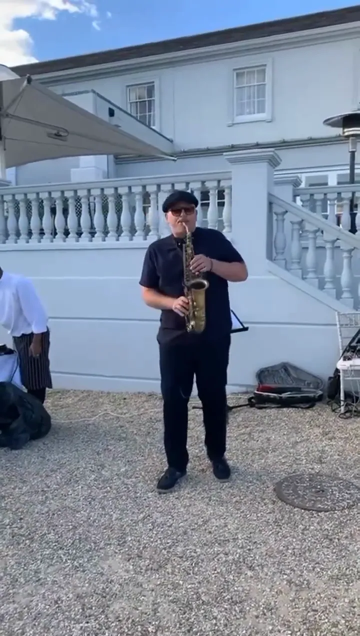 Saxophonist playing at an outdoor drinks reception