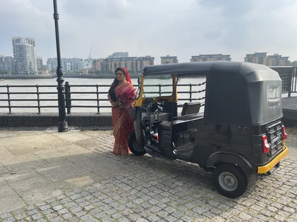 A bride beside a tuk tuk on a waterfront