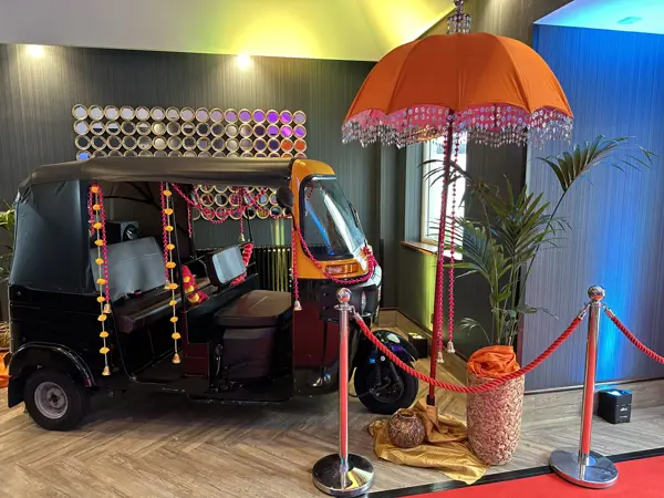 A decorated tuk tuk on a wedding show stand