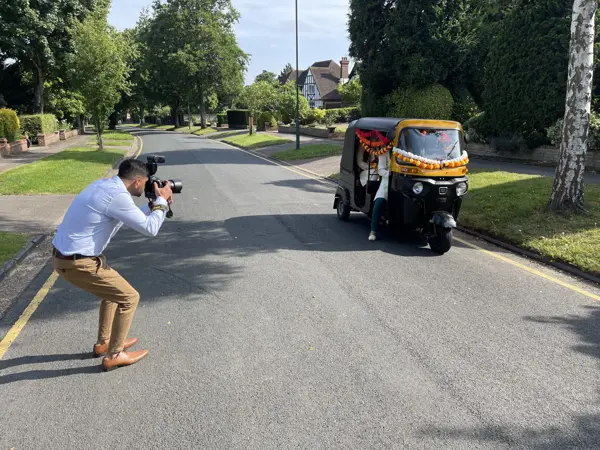 Photographer filming a tuk tuk driving towards the venue