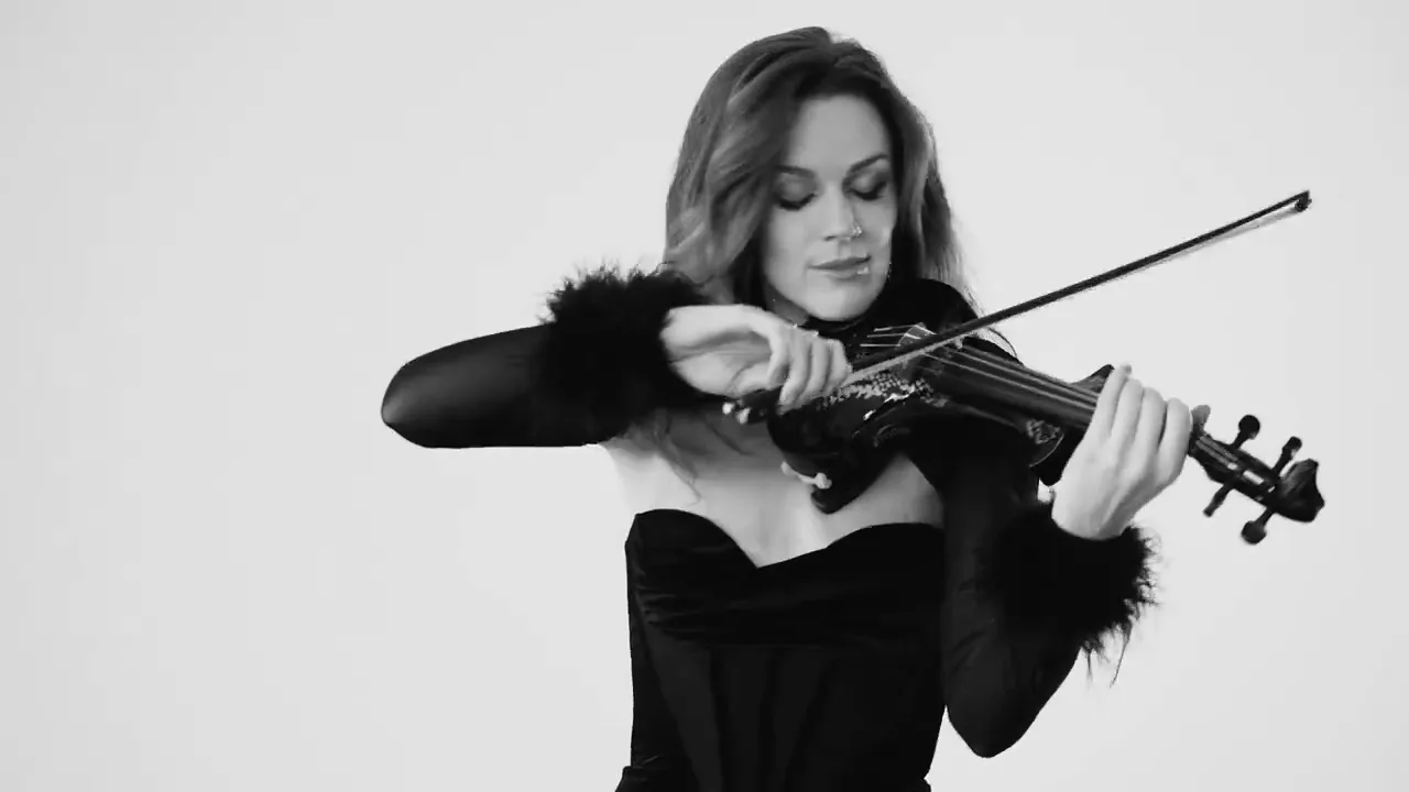 Violinist in black playing in a white studio