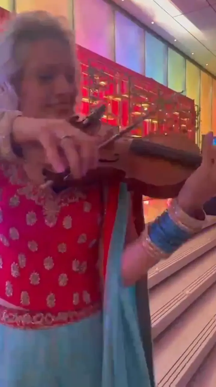 Violinist playing among guests, the UK