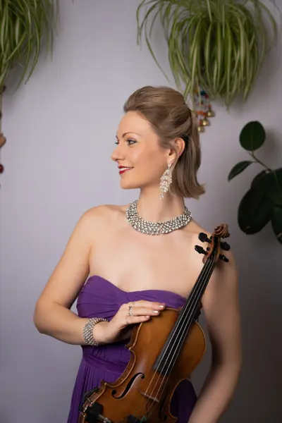 Violinist in a purple gown holding her violin