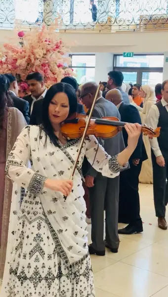 Violinist playing among guests at a reception