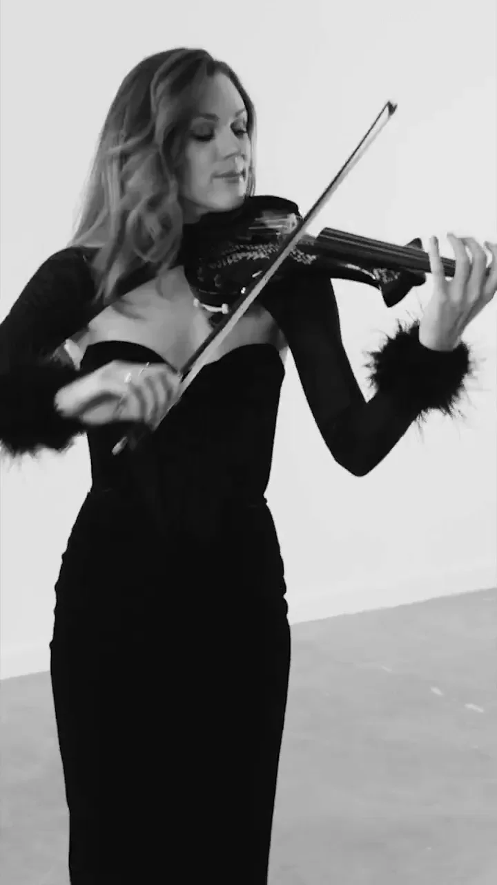 Violinist in black playing in a white studio