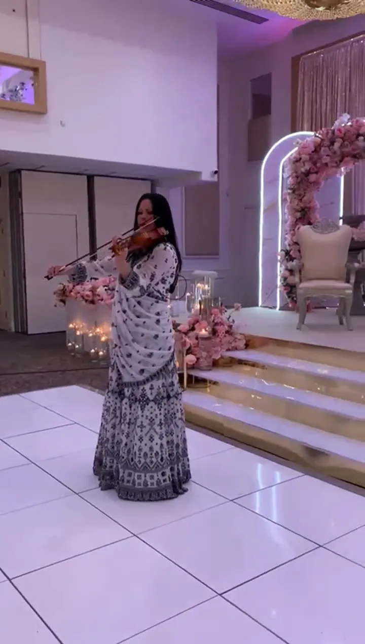 Violinist playing beside a floral stage