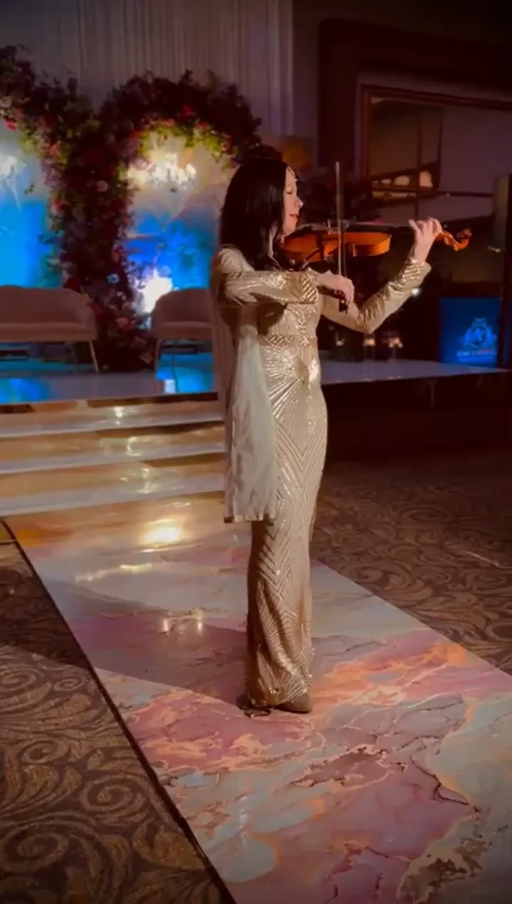 Violinist playing on a floral wedding aisle