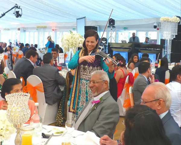Violinist playing between tables at a wedding breakfast