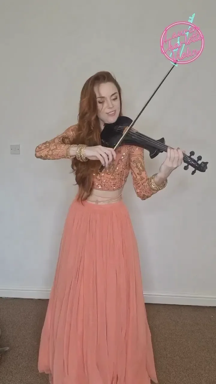 Violinist in a peach lehenga playing a Bollywood song