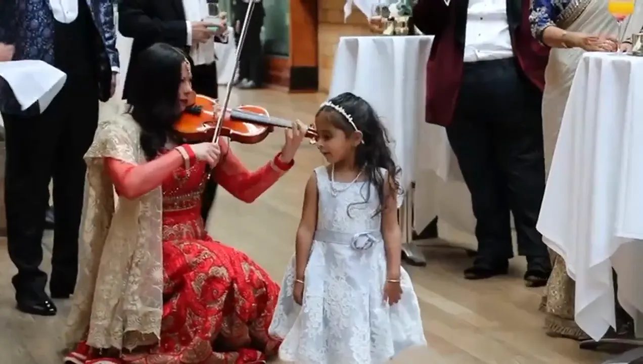 Violinist playing for a young guest at a wedding