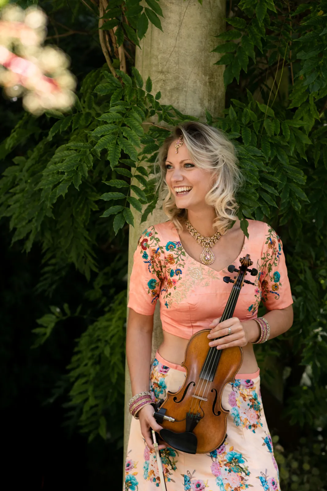 Violinist in a floral lehenga holding her violin