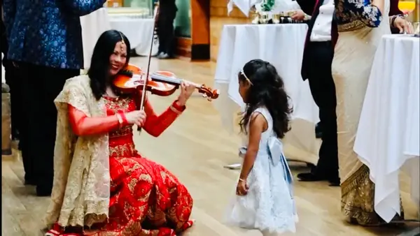 Violinist playing for a young guest at a wedding